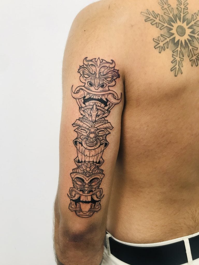 Tatuaje de línea de un tótem en el brazo