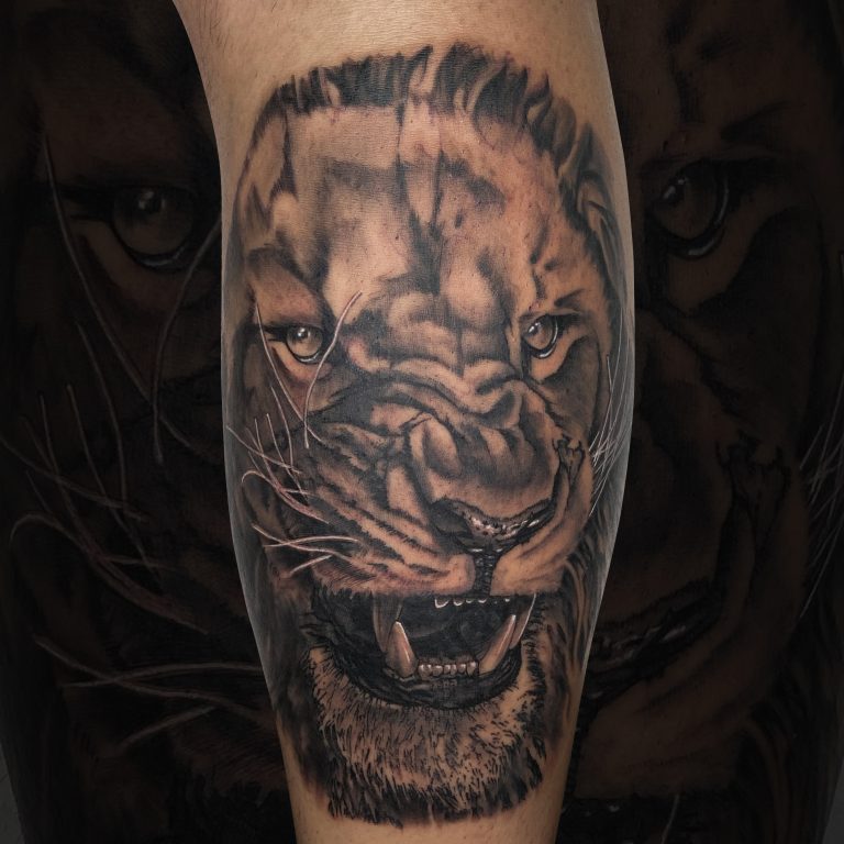 Tatuaje realista de un león en el brazo